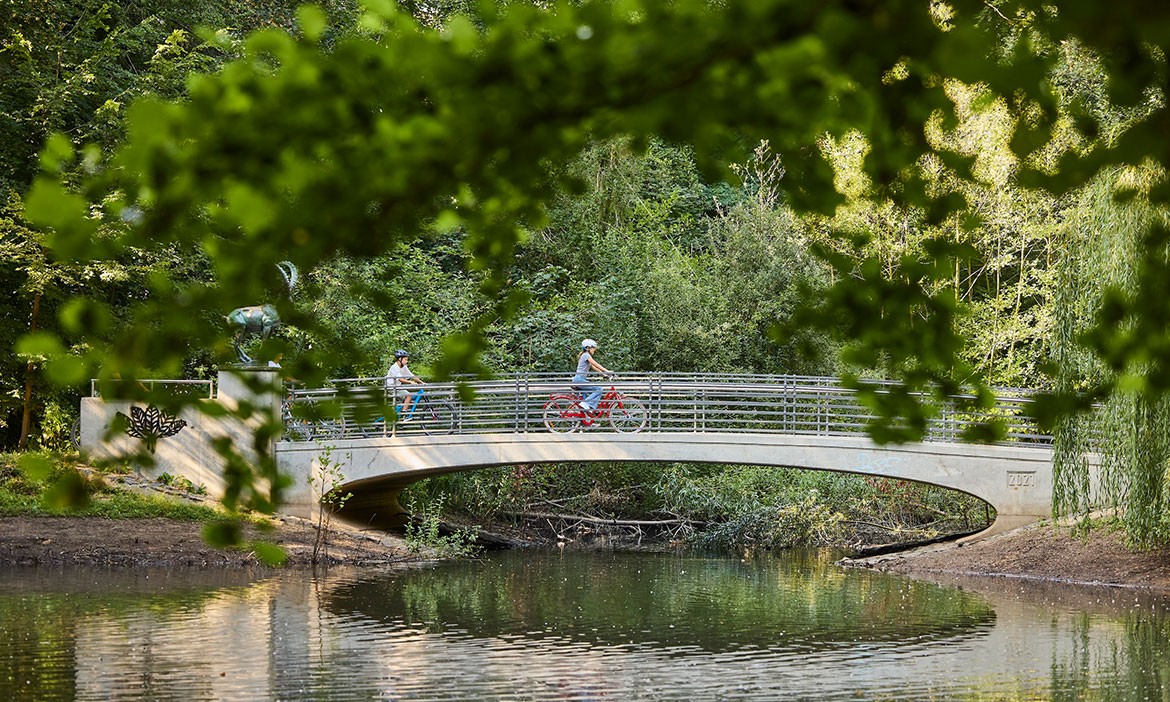 Eilenriede Hannover: Kinder fahren mit dem Fahrrad über eine Brücke